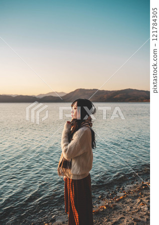 晚上的湖和穿著針織衫和圍巾的年輕女子 121784305