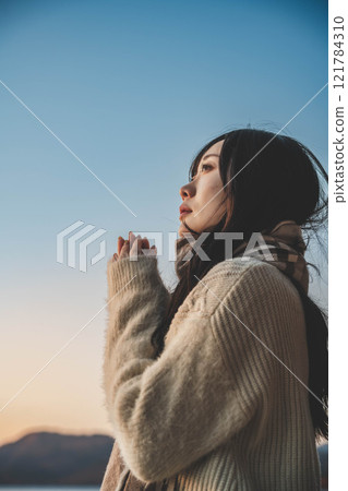 晚上的湖和穿著針織衫和圍巾的年輕女子 121784310