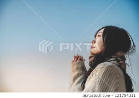 Evening lake and a young woman in a knitted sweater and scarf Evening lake and a young woman in a knitted sweater and scarf 121784311