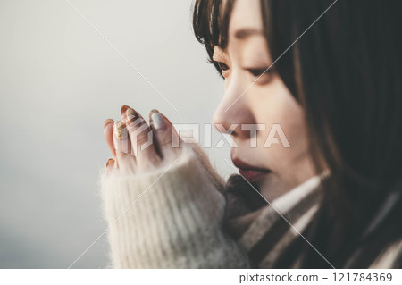 Evening lake and a young woman in a knitted sweater and scarf Evening lake and a young woman in a knitted sweater and scarf 121784369