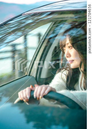 A young woman with long hair driving a car A young woman with long hair driving a car 121784656