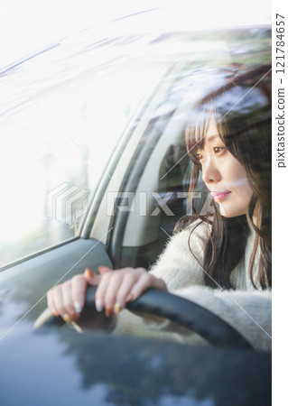 A young woman with long hair driving a car A young woman with long hair driving a car 121784657
