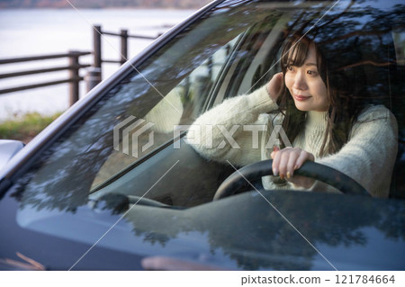 駕駛汽車的長髮年輕女子 駕駛汽車的長髮年輕女子 121784664