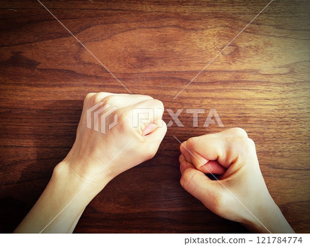A woman's hand clenching her fist on a desk A woman's hand clenching her fist on a desk 121784774