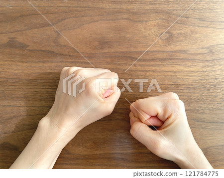 A woman's hand clenching her fist on a desk A woman's hand clenching her fist on a desk 121784775