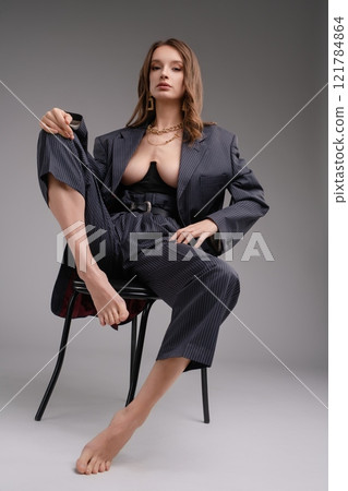 Striking beauty poses elegantly in modern fashion outfit with bold style Striking beauty poses elegantly in modern fashion outfit with bold style 121784864