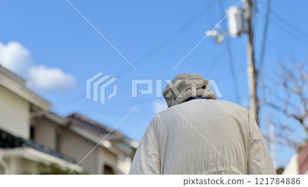 藍天下一位老婦人在住宅區行走的後視 藍天下一位老婦人在住宅區行走的後視 121784886