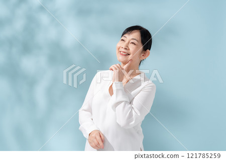 Beauty sunshine filtering through trees Senior woman 121785259