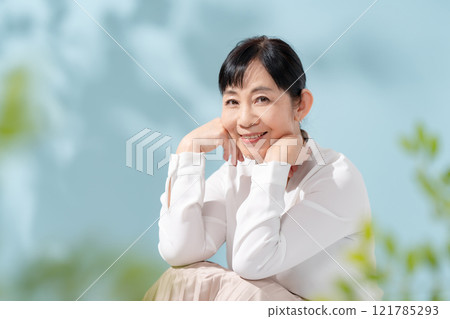 美麗的陽光透過樹木過濾 資深婦女 121785293
