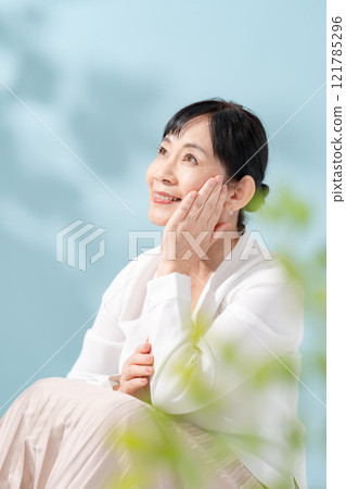 美麗的陽光透過樹木過濾 資深婦女 121785296