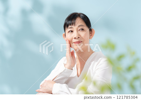 Beauty sunshine filtering through trees Senior woman 121785304