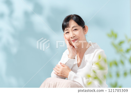 美麗的陽光透過樹木過濾 資深婦女 121785309