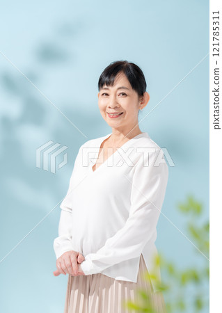美麗的陽光透過樹木過濾 資深婦女 121785311