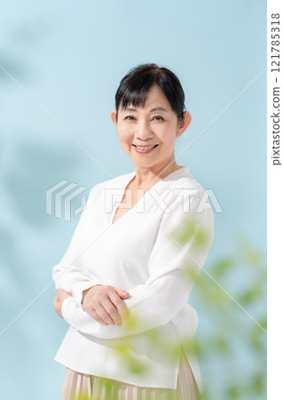 美麗的陽光透過樹木過濾 資深婦女 121785318