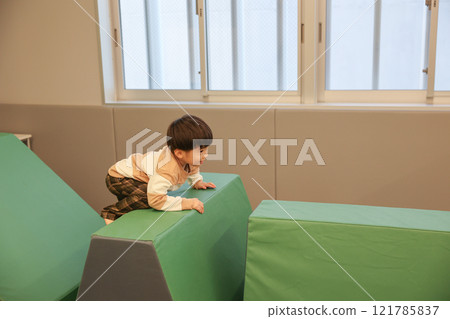 Boy playing with indoor playset 121785837