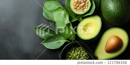 Fresh avocados, spinach leaves and seeds lying on dark background. Avocado background with copy space 121786108
