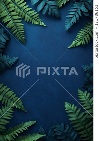 Green fern leaves bordering dark blue background creating copy space 121786153