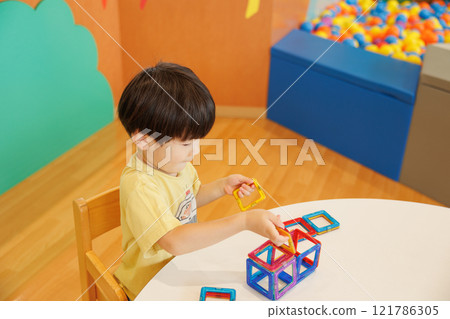 A boy playing with a toy A boy playing with a toy 121786305