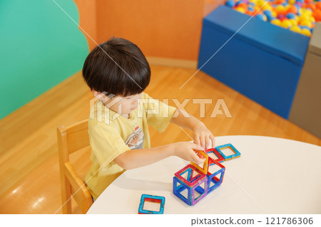 A boy playing with a toy A boy playing with a toy 121786306