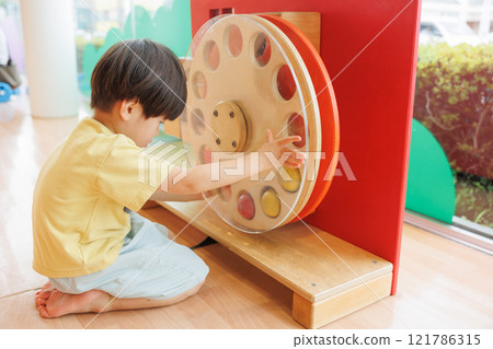 A boy playing with a toy A boy playing with a toy 121786315