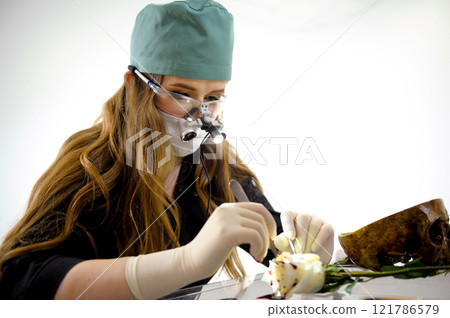 Scientist examining different botanical samples with microscope and test tubes. Noting observations while arranging plants and flowers in various laboratory apparatus 121786579