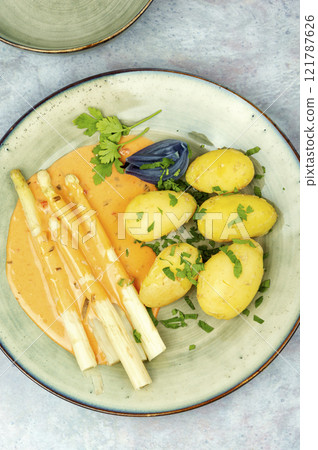 Boiled new potatoes with asparagus. 121787626