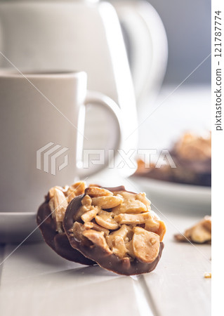 Photography of chocolate Florentines cookies with almonds and chocolate on white table. 121787774