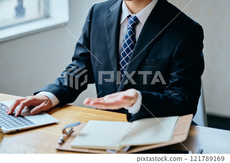 A young man in his 20s serving customers in an office 121789169