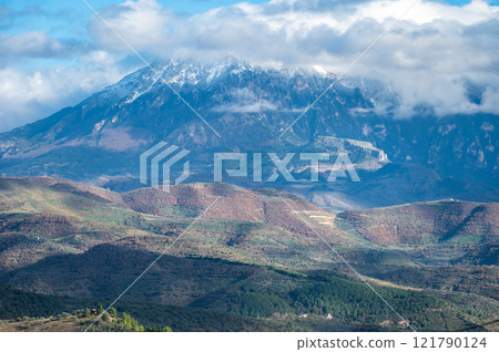 Snow topped mountains and green hills around Berat, Albania 121790124