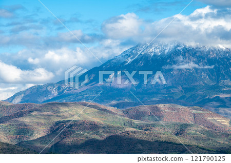 Snow topped mountains and green hills around Berat, Albania 121790125