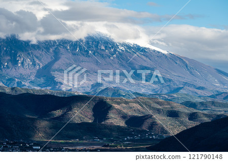 Snow topped mountains and green hills around Berat, Albania 121790148