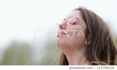 Happy woman in pink sunglasses outdoors smiling 121790236