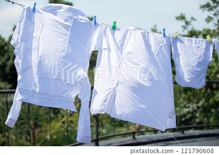The white clothes are hung up and drying in the wind. The white clothes are hung up and drying in the wind. 121790608