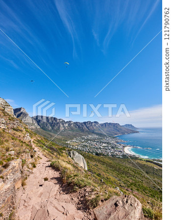 Famous mountain hiking trail with copy space, rough rocks or stones leading to scenic view of Twelve Apostles in Cape Town. Landscape of ocean, sea and coastal city with blue sky from nature reserve 121790762