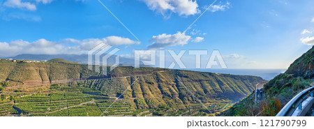 Beautiful landscape of a small agricultural village on a sunny afternoon near a highway or busy road for logistics or transport of goods. Banana plantations in the town of Los Llanos, La Palma, Spain Beautiful landscape of a small agricultural village on a sunny afternoon near a highway or busy road for logistics or transport of goods. Banana plantations in the town of Los Llanos, La Palma, Spain 121790799