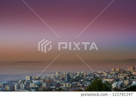 Copy space sunset sky and city view of building infrastructure with sea or ocean background in abroad travel destination. Aerial of Cape Town downtown centre and urban cityscape architecture at night 121791147