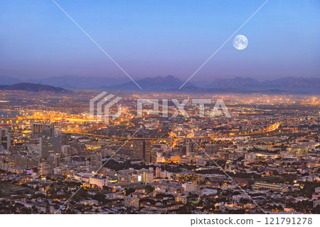 Copy space night view of city buildings with electricity lights, infrastructure and moon with mountain background in travel destination. Cape Town, South Africa downtown centre and urban architecture 121791278