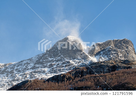 Beautiful landscape of a snowy mountain top with a blue sky and copy space. A streaming peak with frost on a winter afternoon. Peaceful and scenic outdoors with a summit in nature 121791596