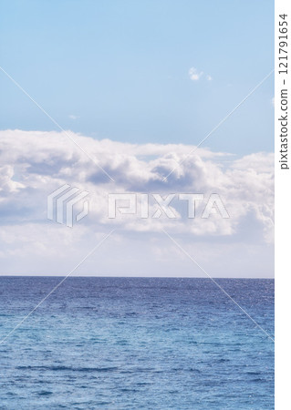 A cloudy blue sky and peaceful, calm ocean separated by a beautiful horizon with copy space. Deep blue water underneath a cloudscape skyline. The many tides, currents and waves in the wide open sea A cloudy blue sky and peaceful, calm ocean separated by a beautiful horizon with copy space. Deep blue water underneath a cloudscape skyline. The many tides, currents and waves in the wide open sea 121791654