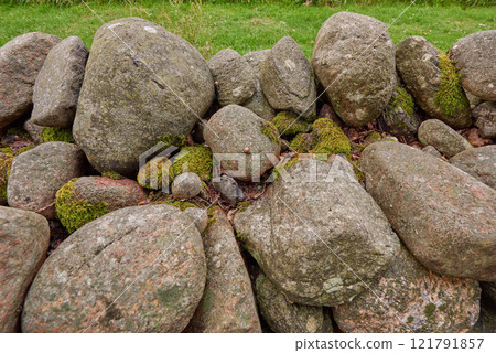 Closeup of a stone wall made of boulders and rocks outside. Background of rustic, rural building and masonry material. Historic housing design or antique architecture of an urban structure outdoors 121791857