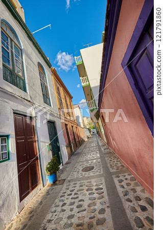 Scenic city street view of old historic houses and traditional residential buildings in an alleyway road in summer. Tourism abroad and overseas travel destinations in Santa Cruz, La Palma in Spain Scenic city street view of old historic houses and traditional residential buildings in an alleyway road in summer. Tourism abroad and overseas travel destinations in Santa Cruz, La Palma in Spain 121791860