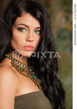 Confident young adult woman with long wavy hair and make-up fashion portrait 121792262
