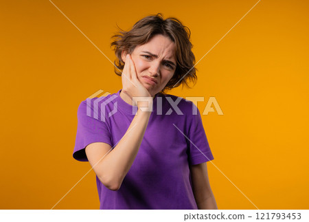 Young pretty woman with tooth pain, yellow background. Toothache, dental problem 121793453
