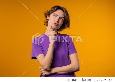 Thinking around stylish woman on yellow background. Puzzled lady looking answer 121793458