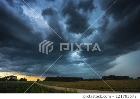 Dramatic storm clouds over wheat field, creating threatening atmosphere in countryside Dramatic storm clouds over wheat field, creating threatening atmosphere in countryside 121793572