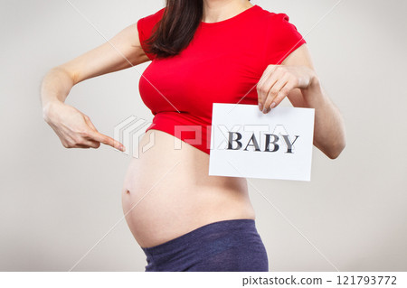 Woman in pregnant holding card with inscription baby. Expecting birth of newborn. Extending family 121793772