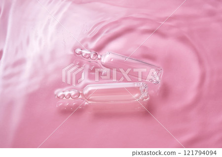 Ampoules in water on a pink background. Ampoules in water on a pink background. 121794094