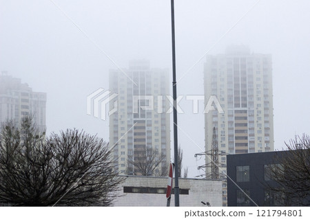 High-rise buildings in Kyiv are shrouded in dense fog, their silhouettes barely visible, creating a mysterious and quiet urban landscape 27.12.2024 121794801