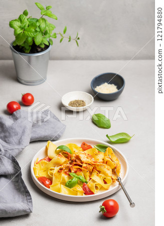 Homemade tagliatelle or pappardelle pasta with tomato sauce, basil and parmesan cheese in a plate Homemade tagliatelle or pappardelle pasta with tomato sauce, basil and parmesan cheese in a plate 121794880