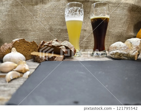 slices of bread and glasses of beer are located near the sliced granite board 121795542